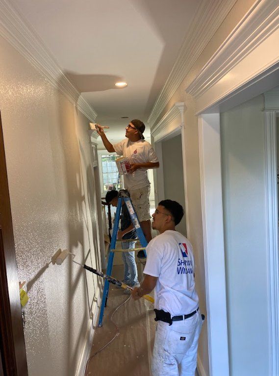 Crew painting hallway walls and crown molding